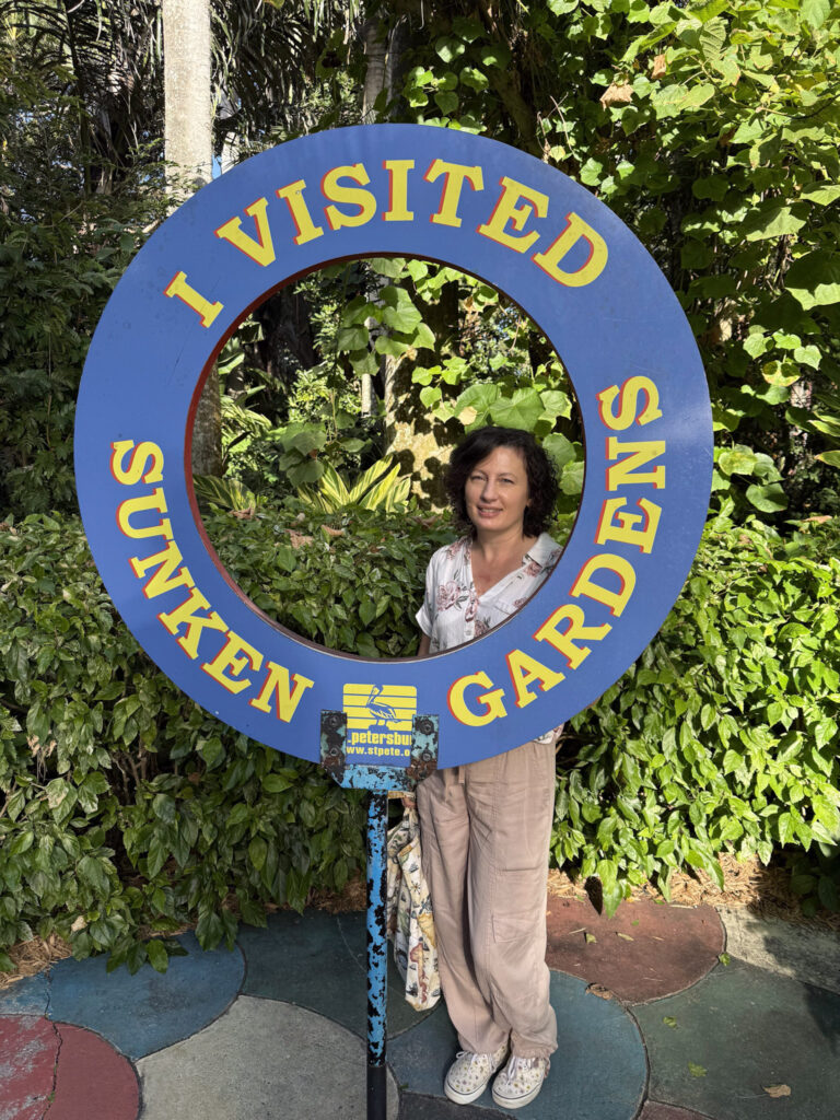 Photo of me standing next to a circular "I visited Sunken Gardens" sign.